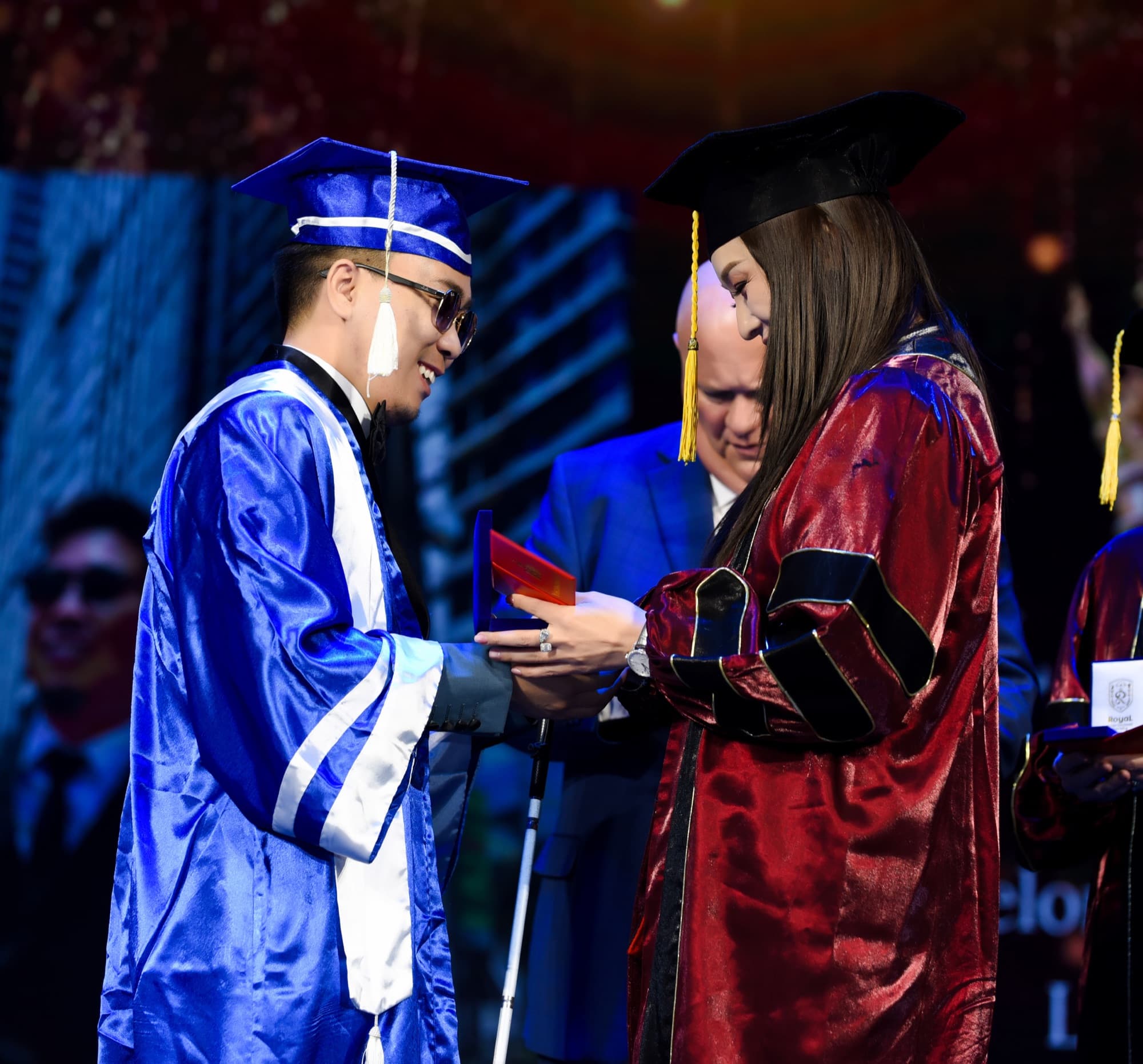A graduate receives a diploma on stage