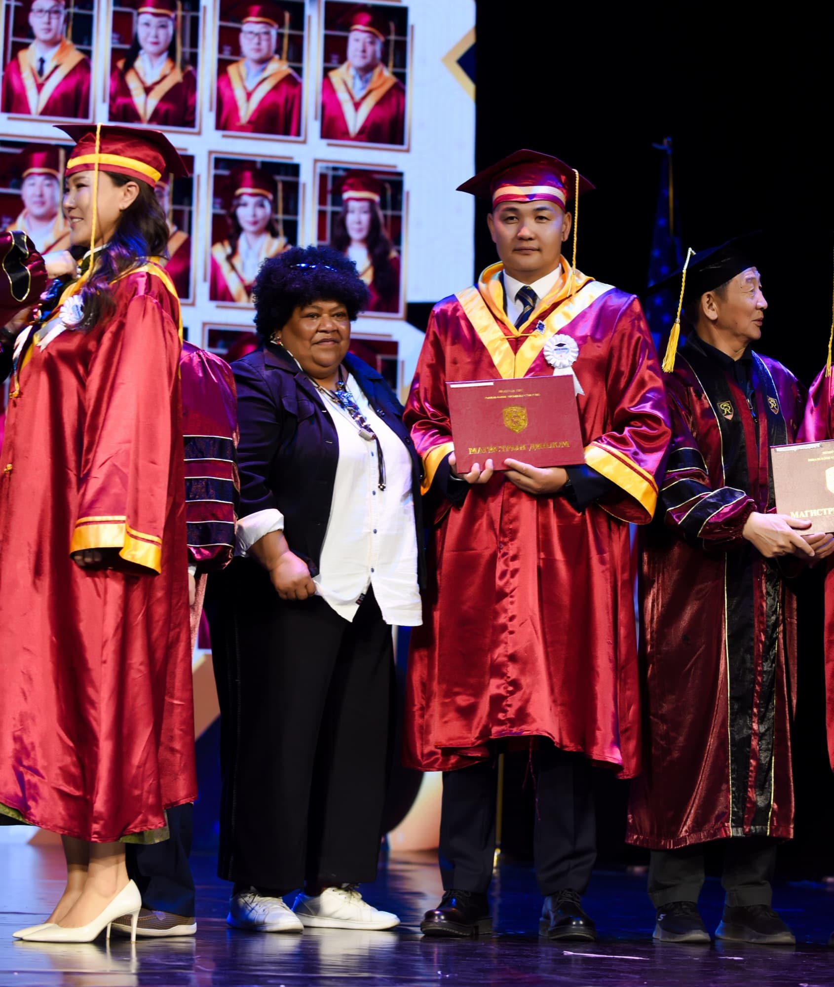 A graduate holds the RIU diploma folder